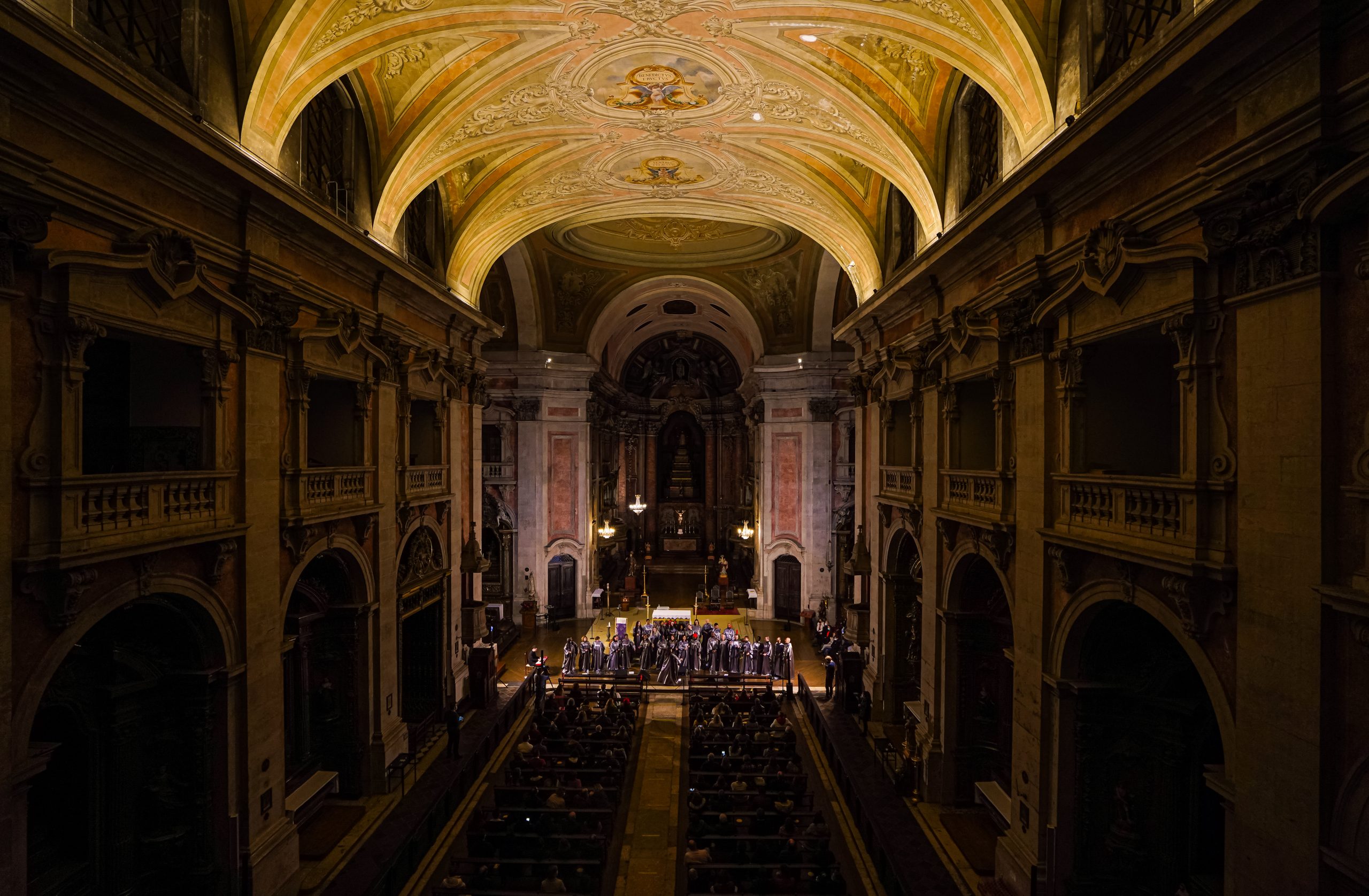 Interior de Igreja, um coro atua junto ao altar. 