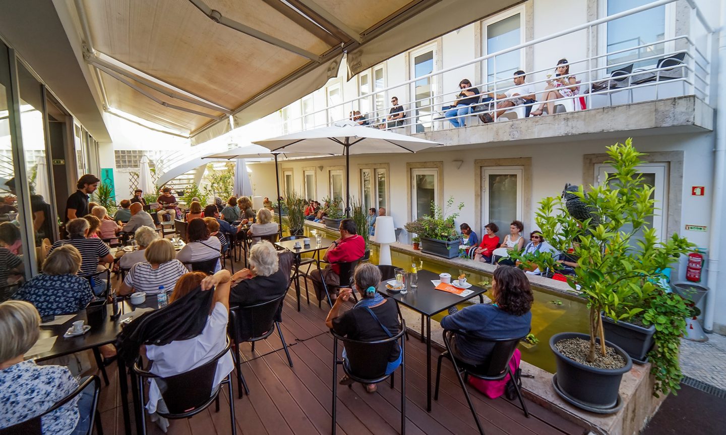 Esplanada com pessoas sentadas a ver um espetáculo