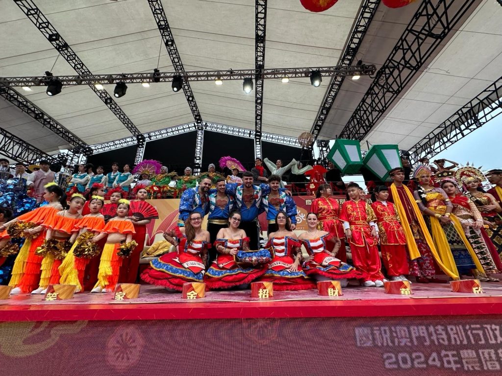 palco com pessoas em trajes populares portugueses e orientais