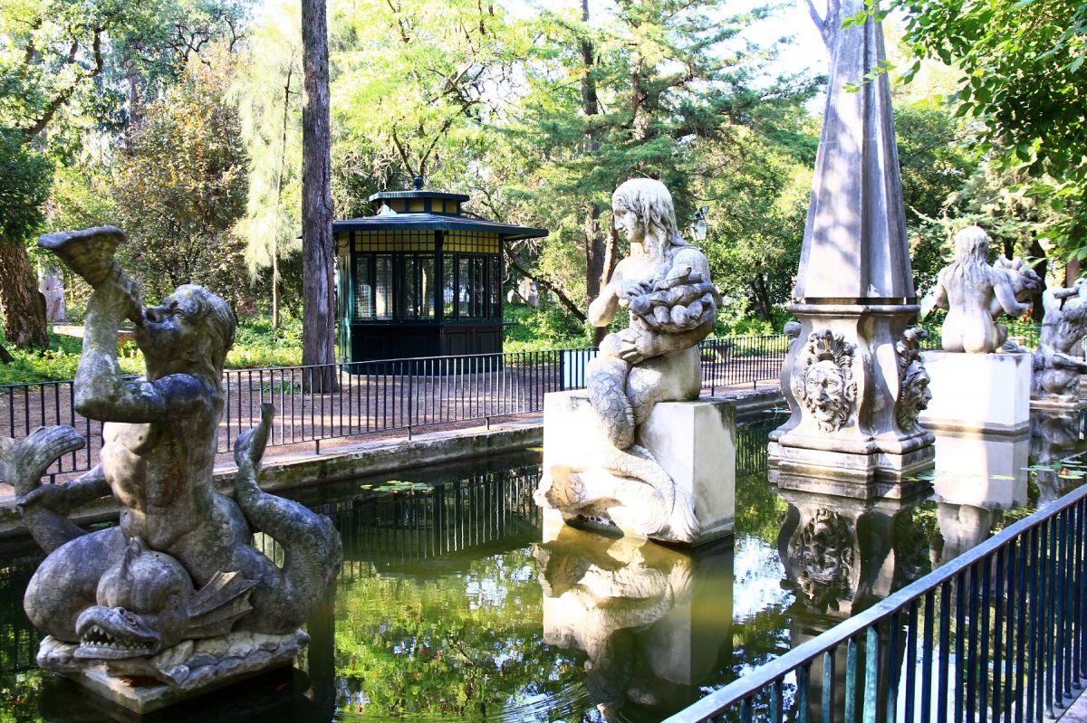 Lago do Palácio Pimenta com estátuas e quisoque ao fundo.