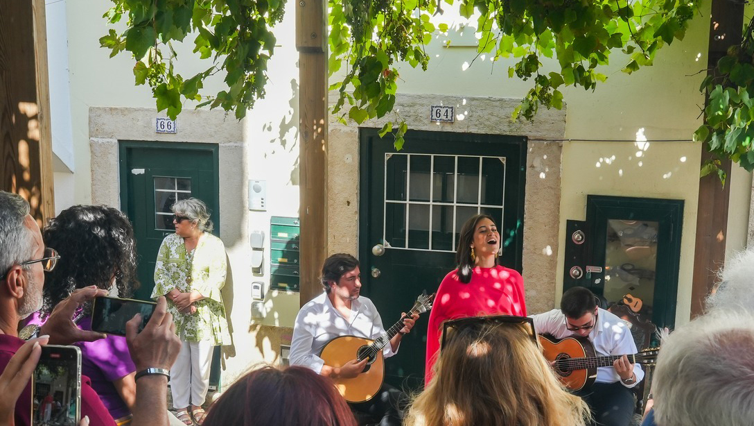 Rapariga a cantar na rua com 1 viola e 1 guitarra portuguesa