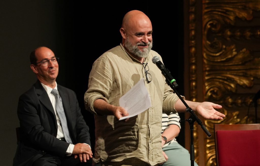 Homem no palco a falar. 