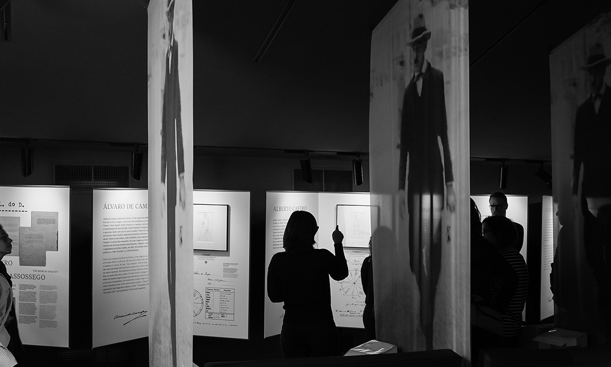 silhueta de mulher a apontar para painel expositivo