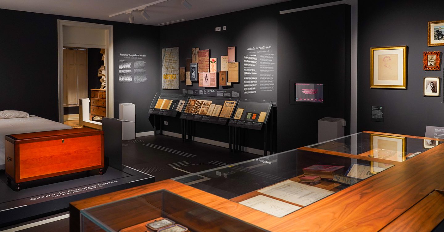 sala de exposição com livros e uma cama