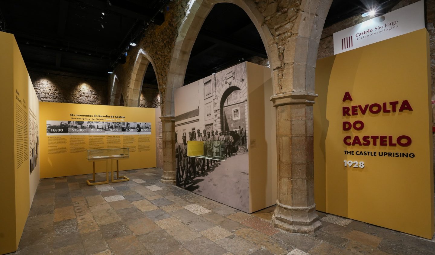 paineis expositivos numa sala de pedra com ogivas 