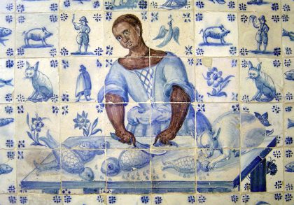 Fotografia de um painel de azulejos da cozinha do Palácio Pimenta com a imagem de uma mulher negra a amanhar peixe