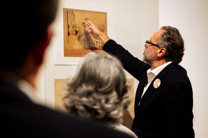 Fotografia do comissário a apontar para uma obra da exposição