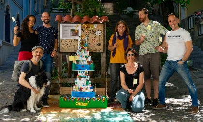Fotografia de várias pessoas e um cão junto a um trono de Santo António