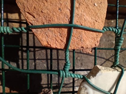 Imagem de uma pedra com uma rede verde à frente