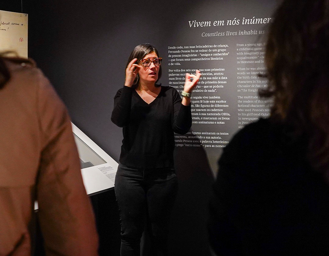 Intérprete de Língua Gestual Portuguesa, de pé, com as mãos em movimento ativo